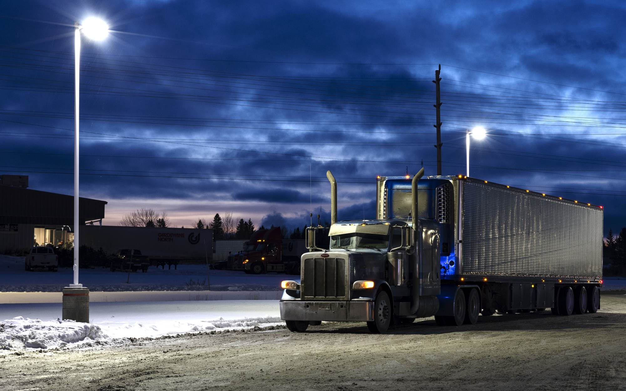 Semi truck at blue hour under lot lights